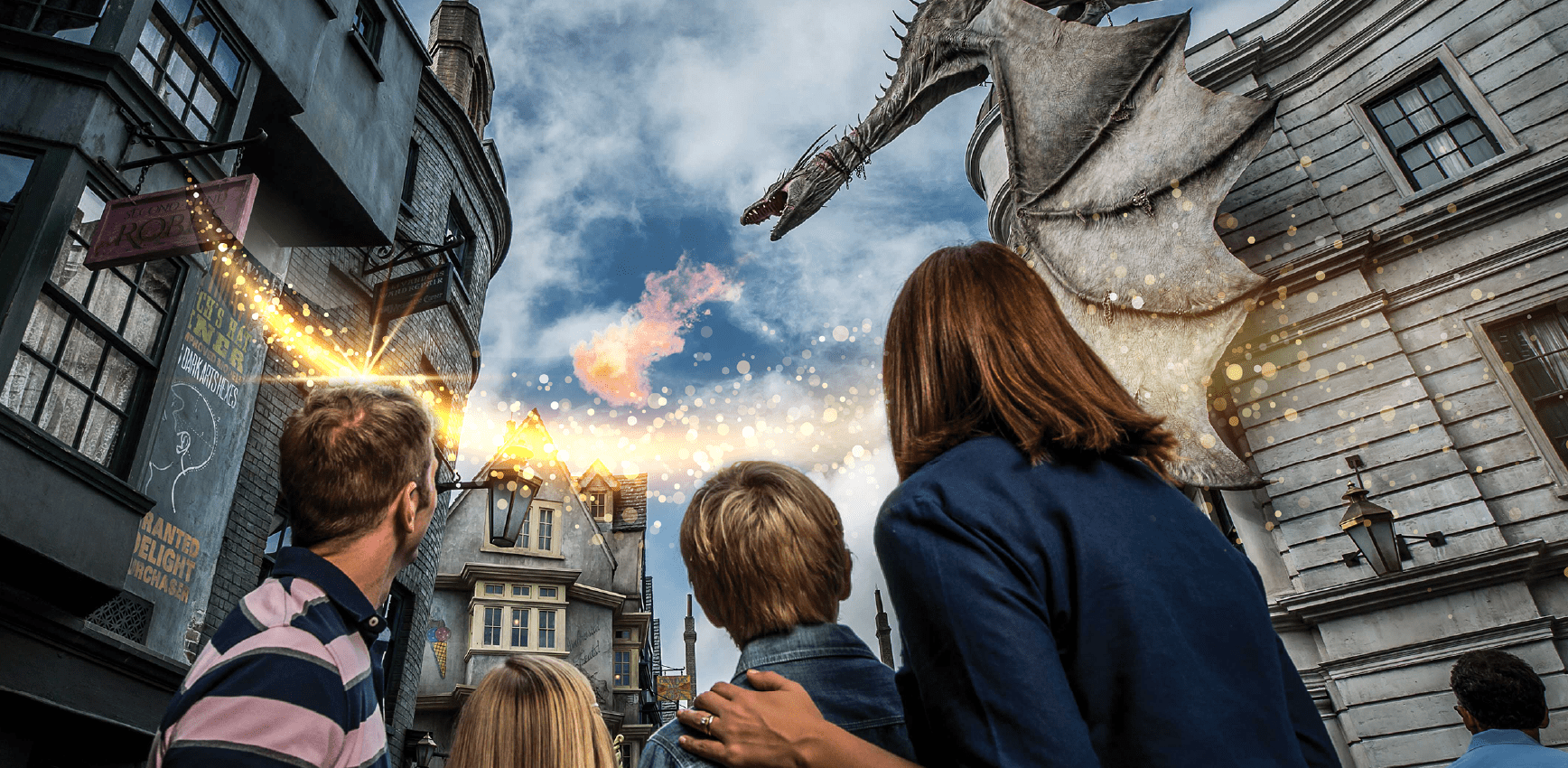 A family looks up as a fire‑breathing dragon towers above a magical, fantasy-style street scene with glowing spark effects.
