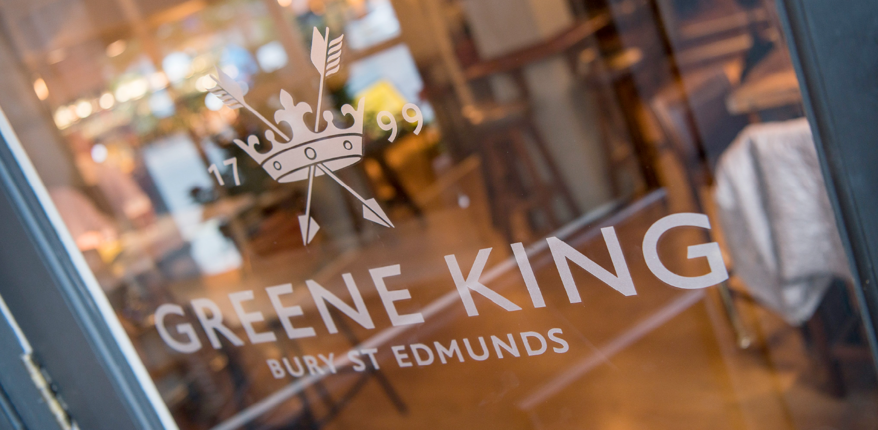Greene King logo on a pub window.