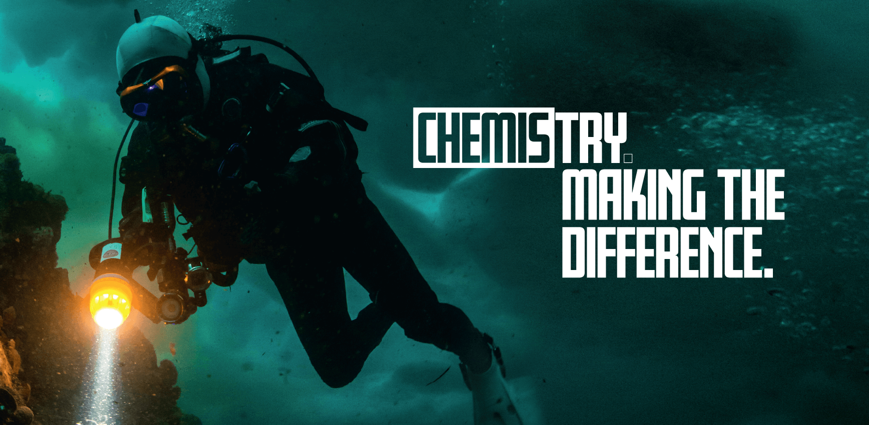 A diver swims underwater, illuminated by beams of light, with the text "Chemistry – try making the difference.