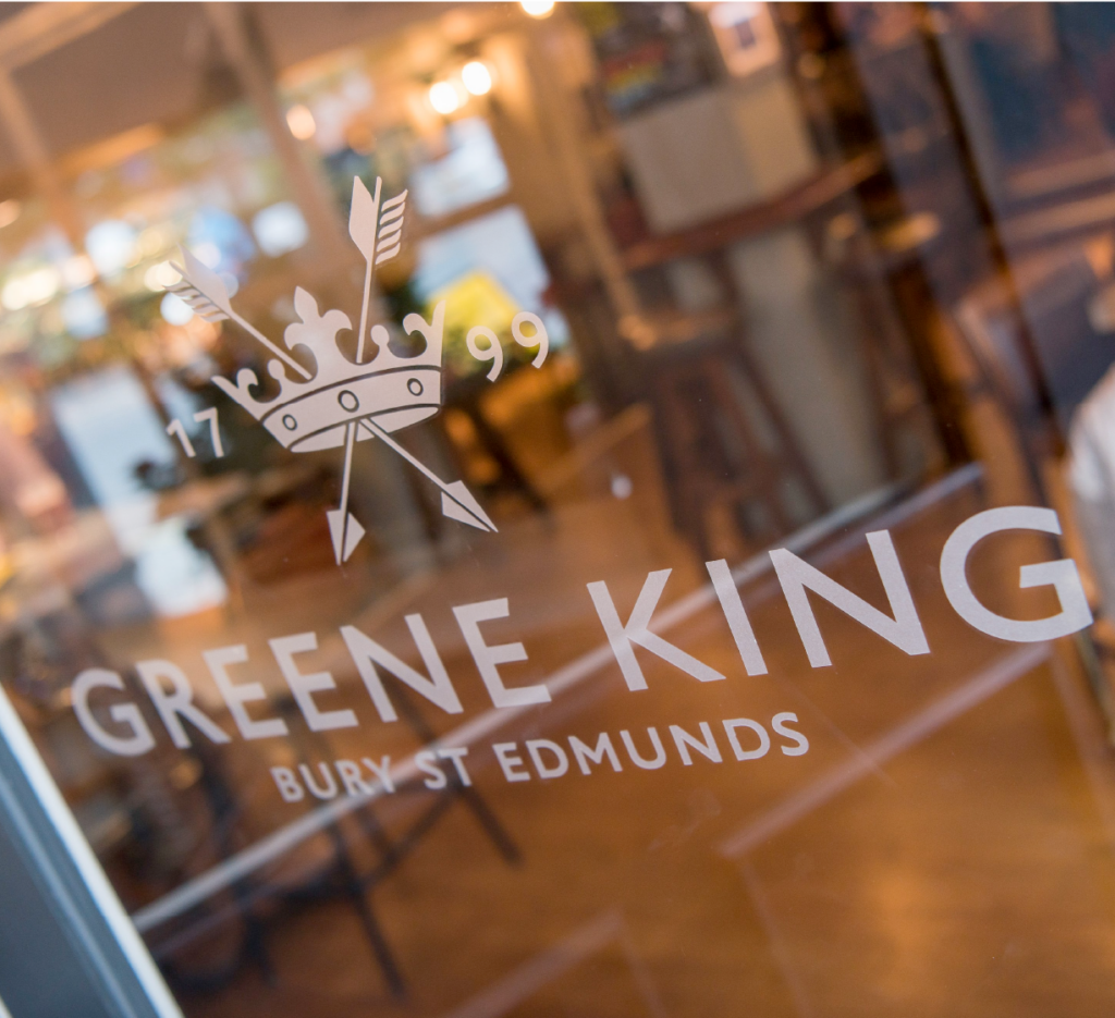 Glass door featuring the Greene King logo and text, with a pub interior visible in the background.