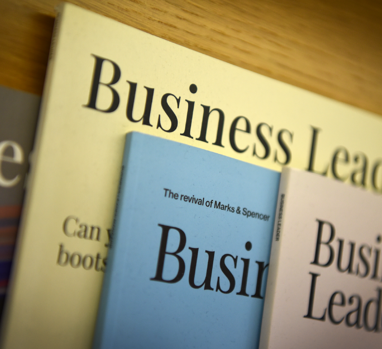 Close-up of Business Leader magazines on a shelf.