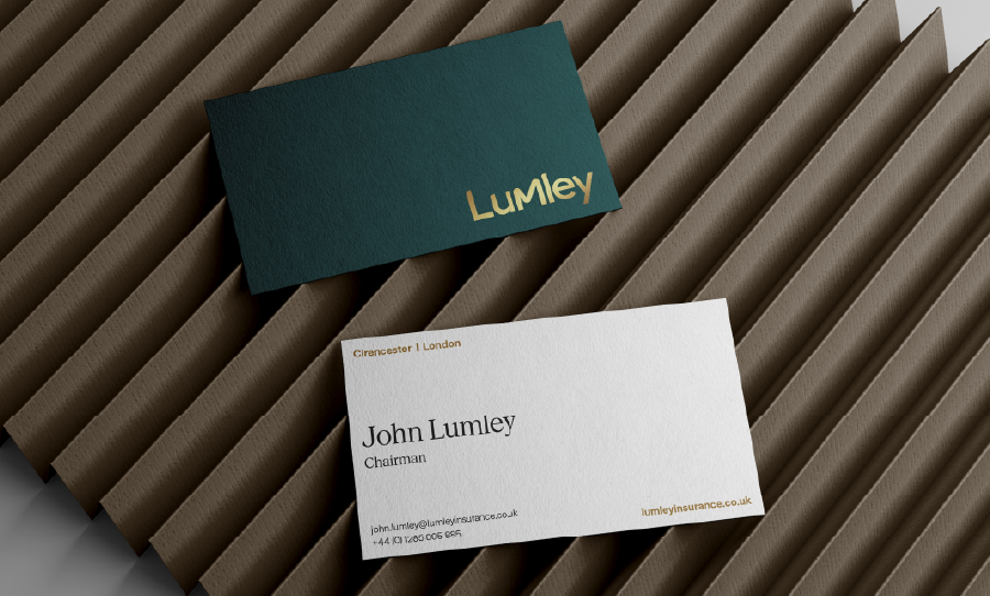 Lumley business cards on a textured surface, featuring logo and contact details.