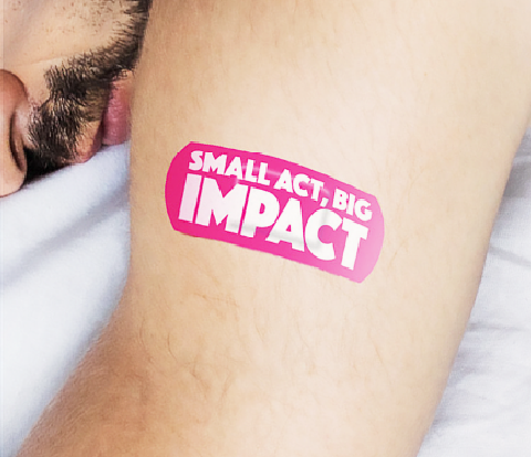 'Small Act, Big Impact' written on pink plaster on top of someones arm.