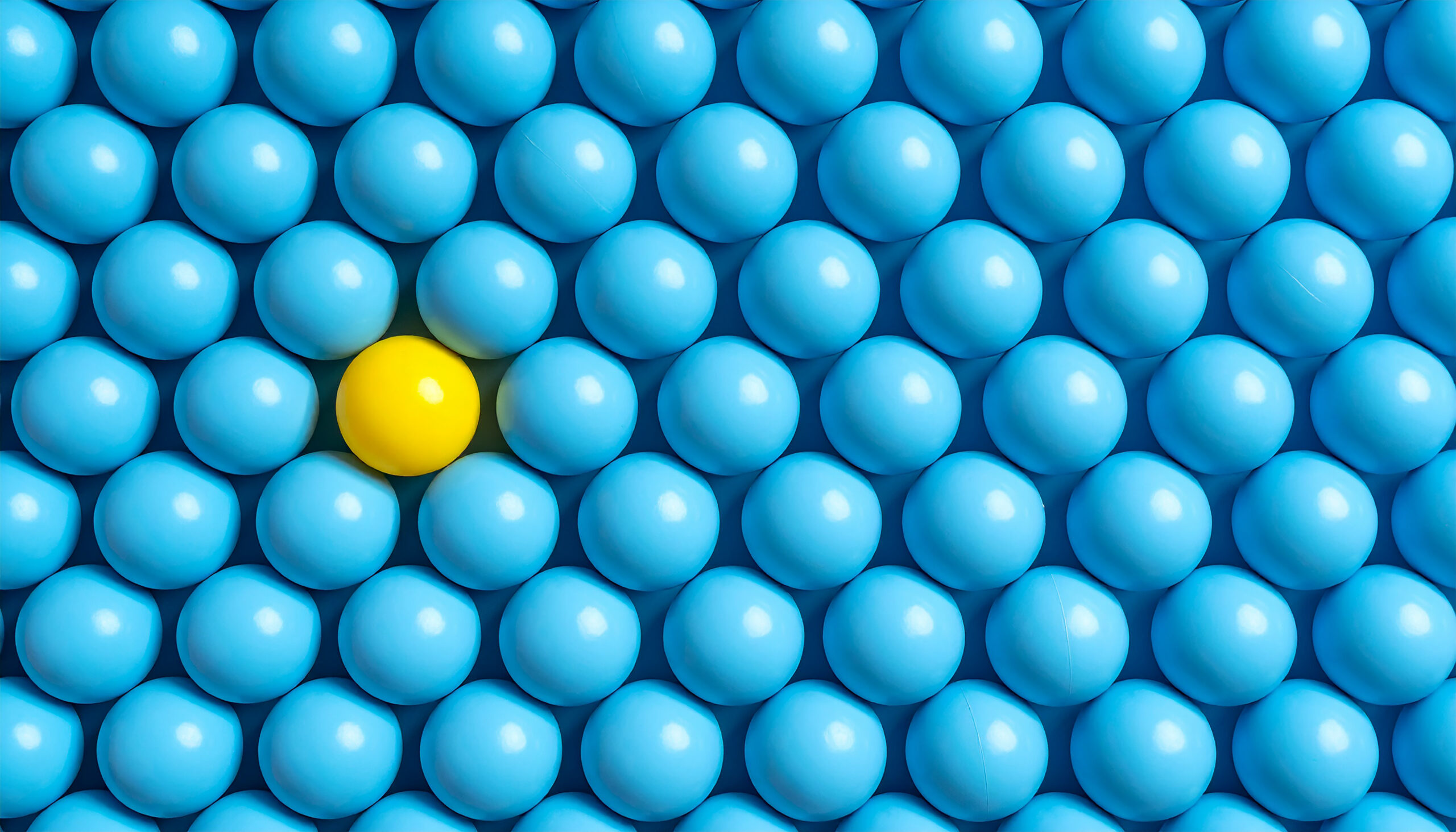 Lots of sky blue balls with 1 odd yellow ball.